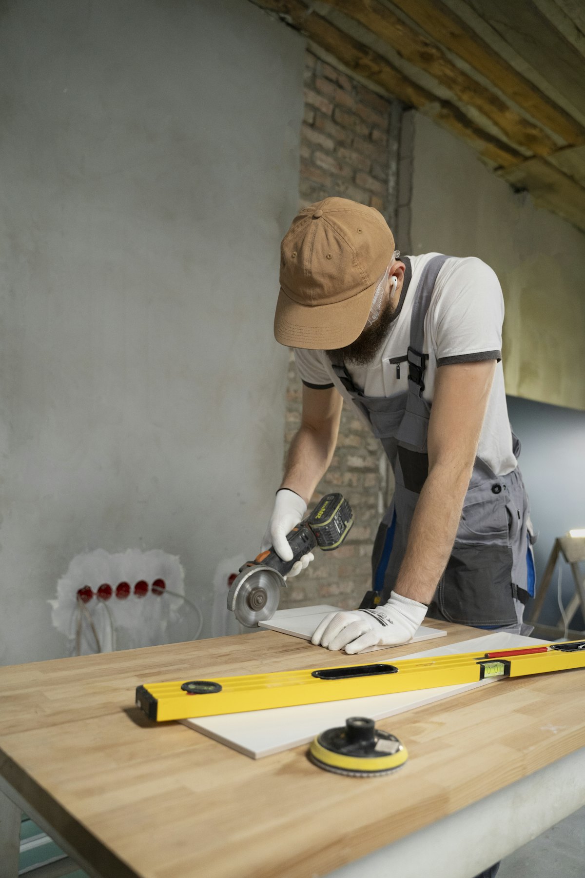 A tradesperson cutting a tile with an angle grinder